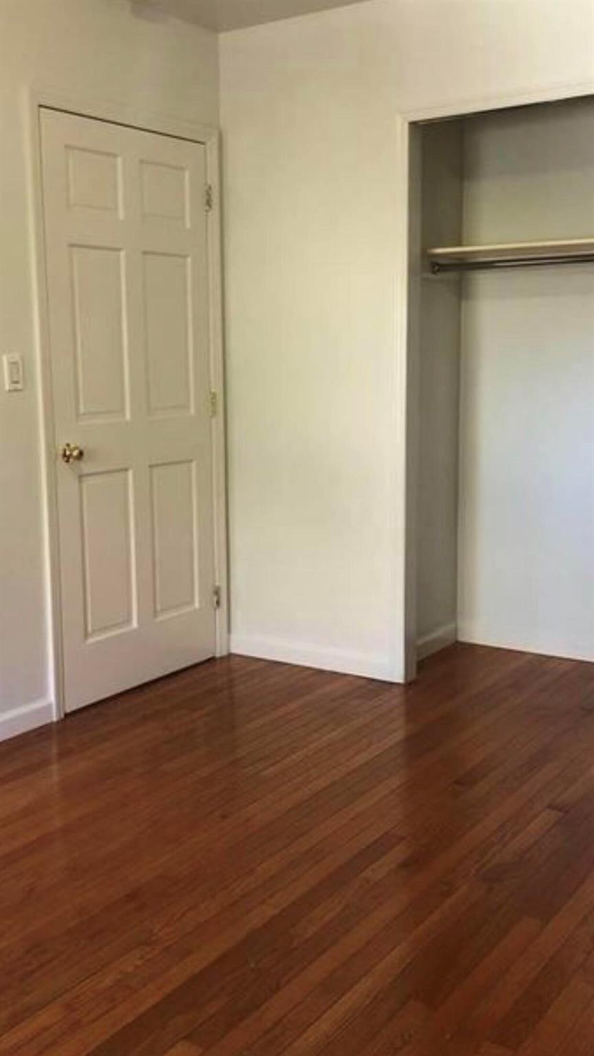 142-28 37th Avenue, Unit 3B Queens, NY 11354 - Photo 2 of 3 a view of an empty room with wooden floor and closet