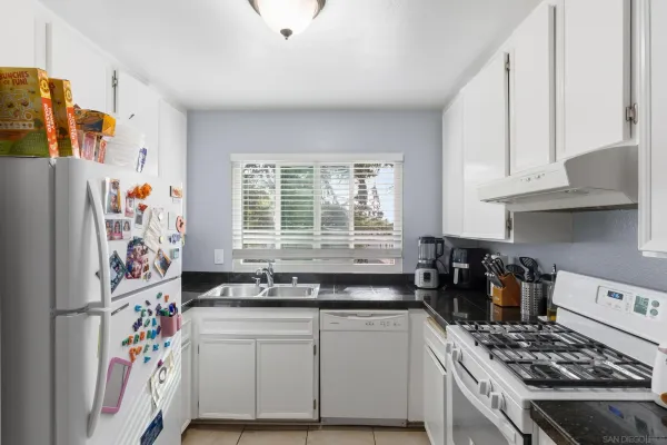 a kitchen with stainless steel appliances a stove a sink and a refrigerator
