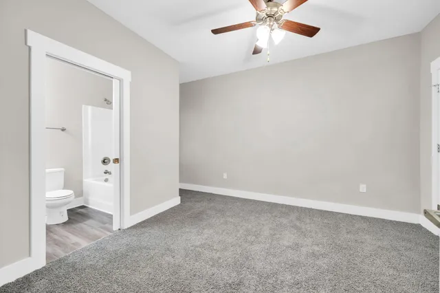 an empty room with a bathroom and a toilet