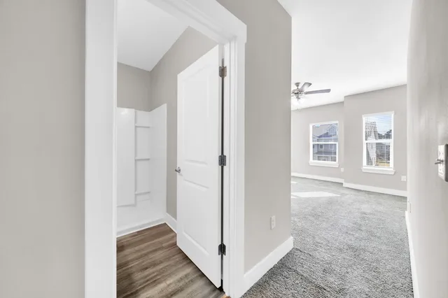 a view of a hallway with wooden floor and closet