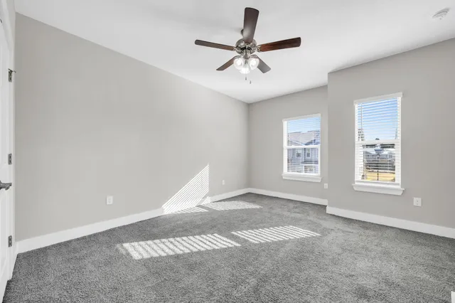 a view of a livingroom with a ceiling fan and window