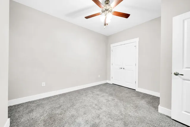 an empty room with a chandelier fan