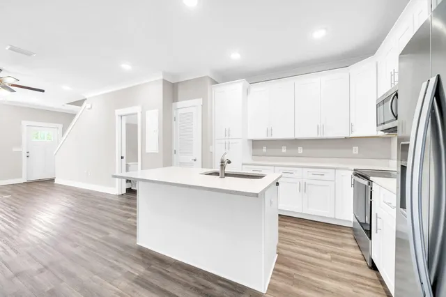 a kitchen with stainless steel appliances granite countertop a sink stove and refrigerator