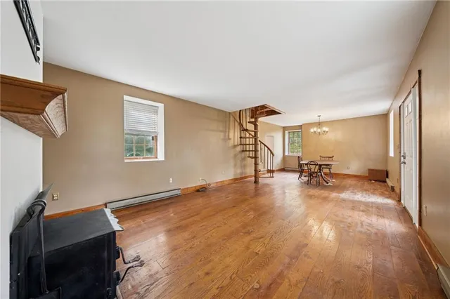 an empty room with a fireplace and wooden floor