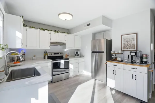a kitchen with white cabinets and stainless steel appliances