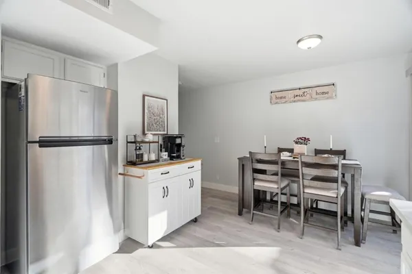 a kitchen with stainless steel appliances a refrigerator a stove a dining table and chairs