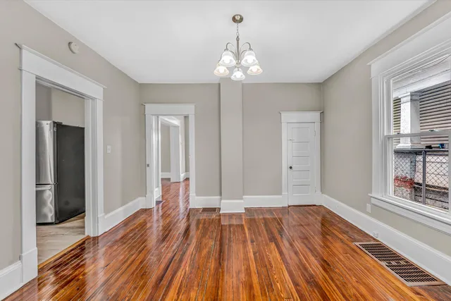 wooden floor chandelier and windows in a room