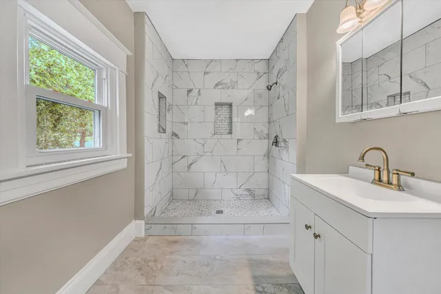 a bathroom with a shower sink and mirror