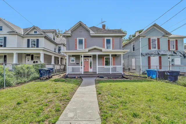 a front view of a house with a yard and trees