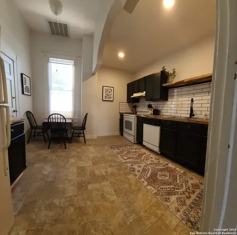 a large kitchen with a table and chairs in it