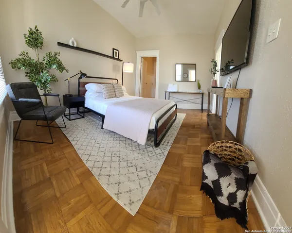 a bedroom with bed and wooden floor