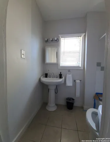 a bathroom with a sink toilet and a mirror