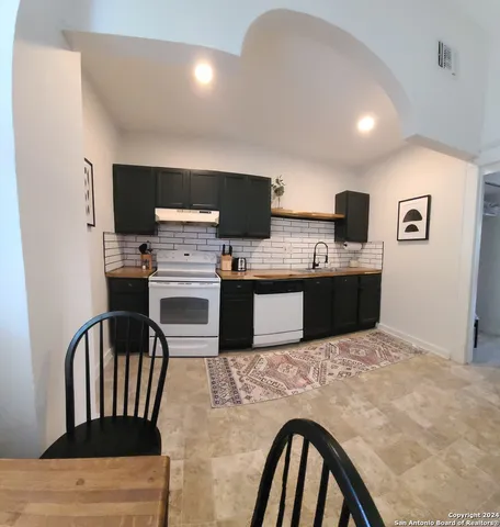 a kitchen with kitchen island a stove and a refrigerator