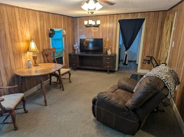 a living room with furniture a flat screen tv and kitchen view