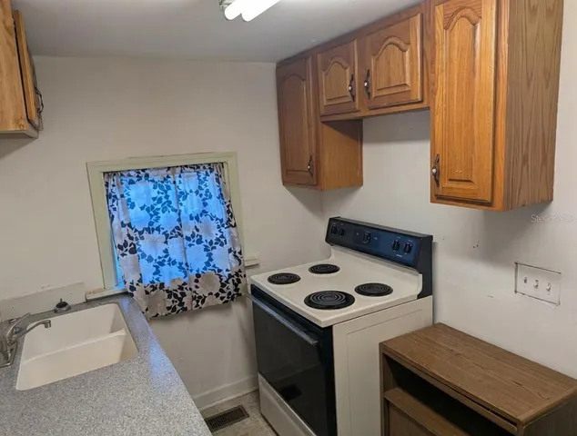 a white stove top oven sitting inside of a kitchen