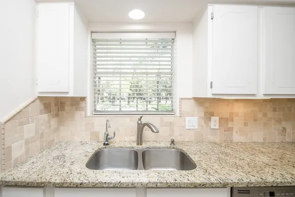 a kitchen with granite countertop a stove sink and microwave