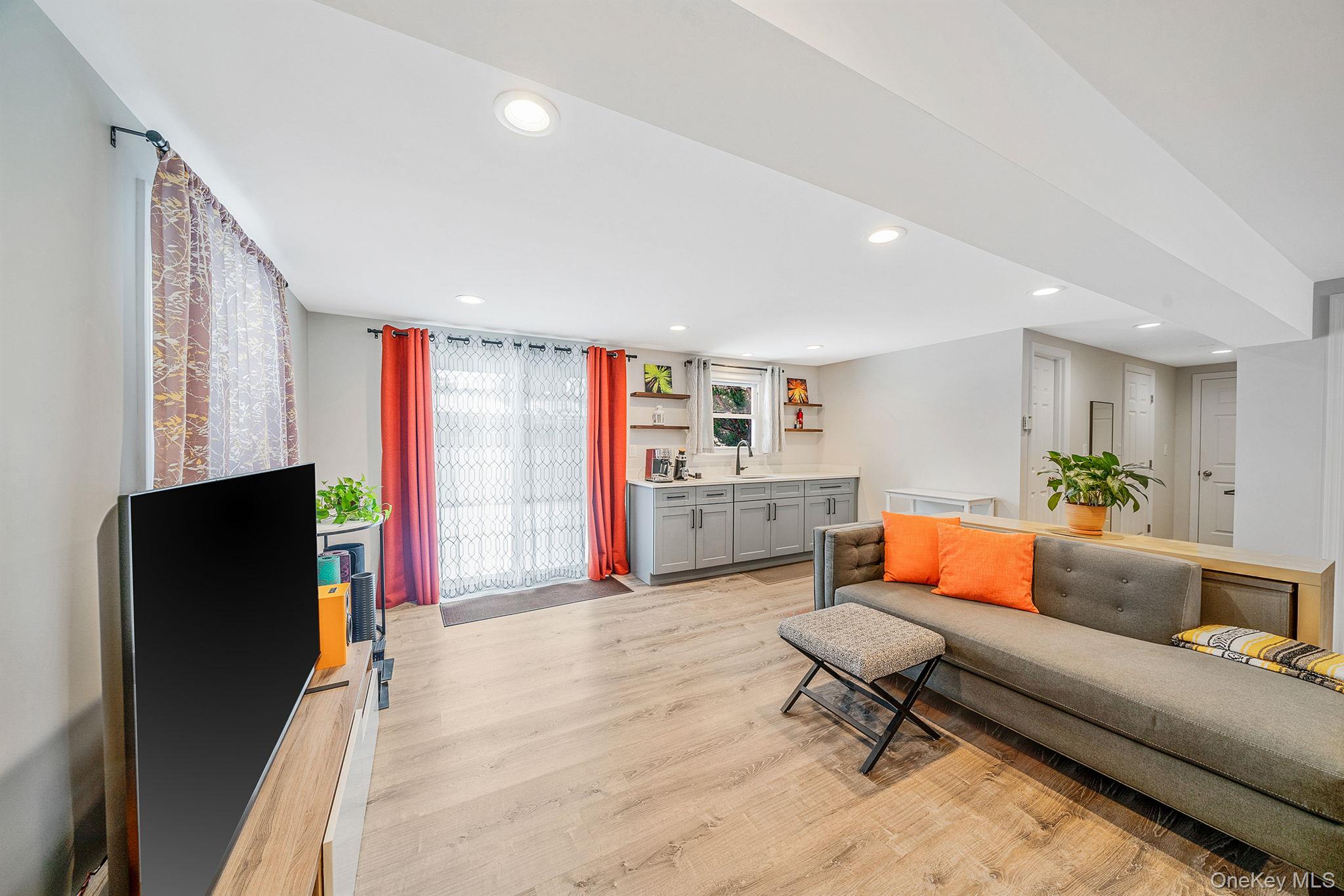 1663 Claas Avenue Holbrook, NY 11741 - Photo 15 of 28 a living room with furniture a flat screen tv and a refrigerator