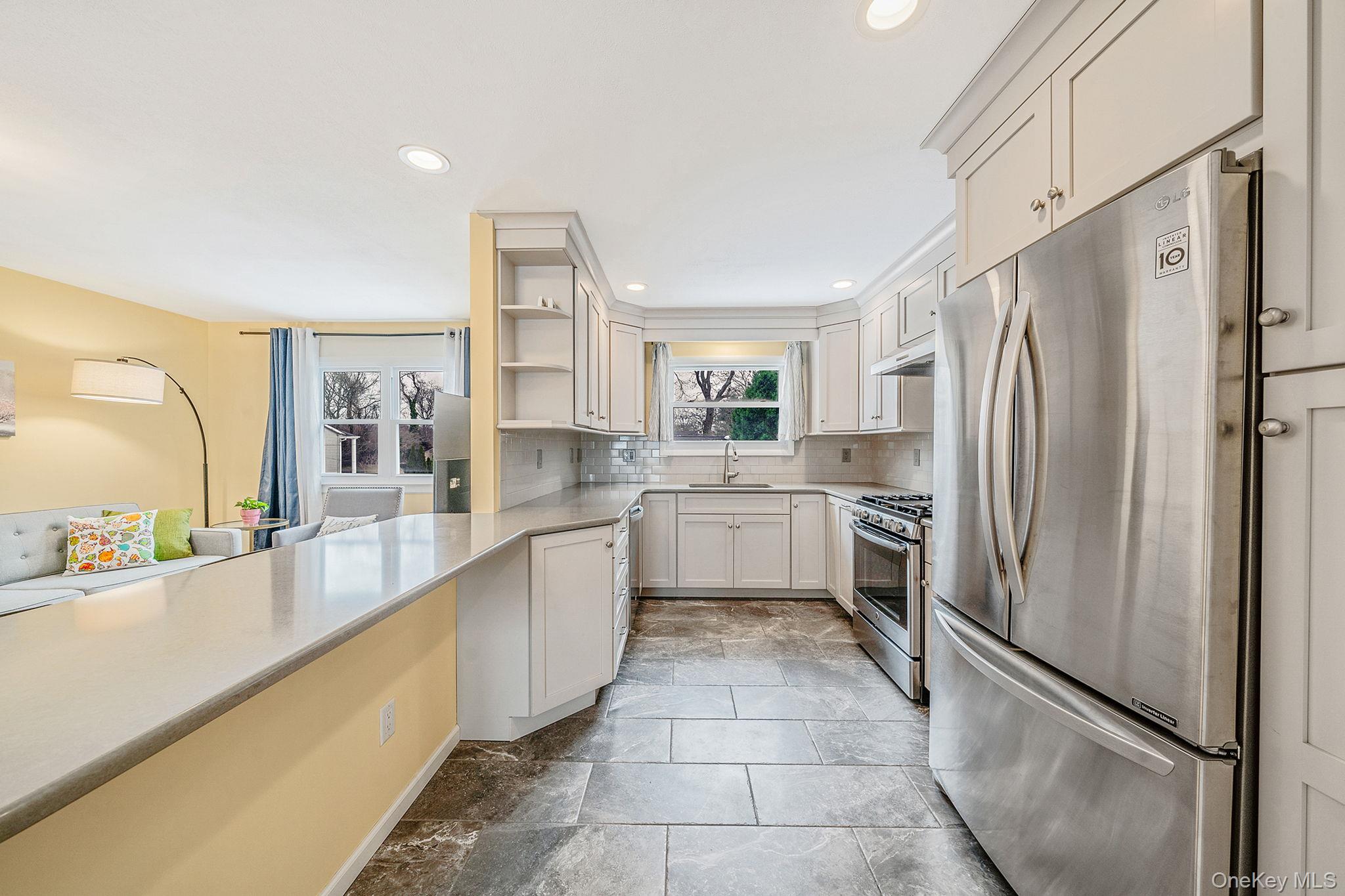 1663 Claas Avenue Holbrook, NY 11741 - Photo 5 of 28 a large kitchen with a refrigerator a sink and cabinets