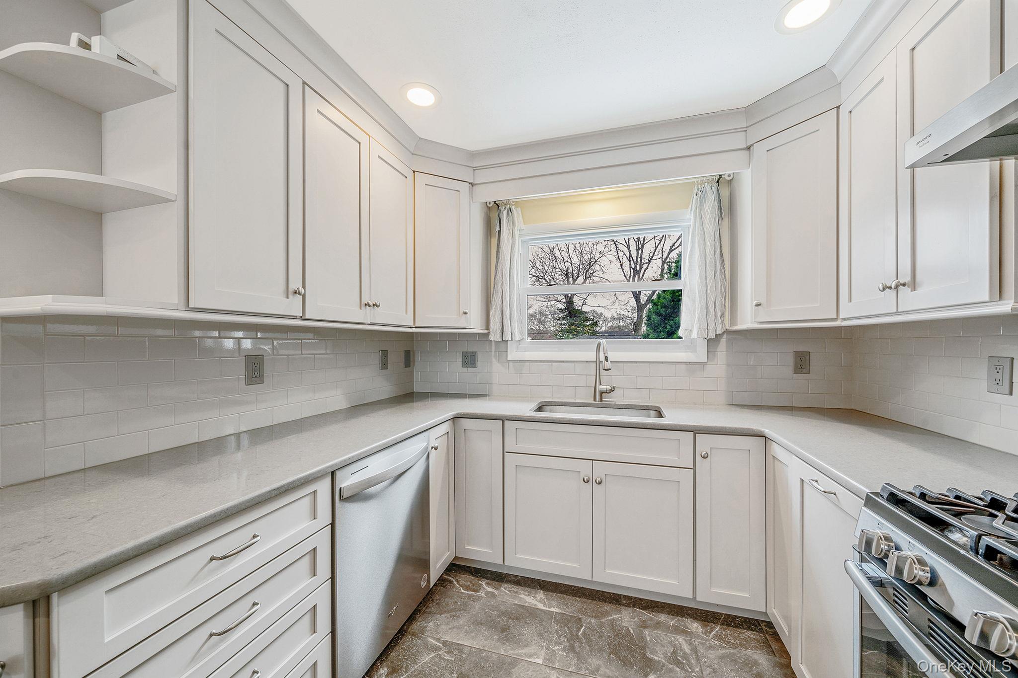 1663 Claas Avenue Holbrook, NY 11741 - Photo 6 of 28 a kitchen with white cabinets white stainless steel appliances and sink