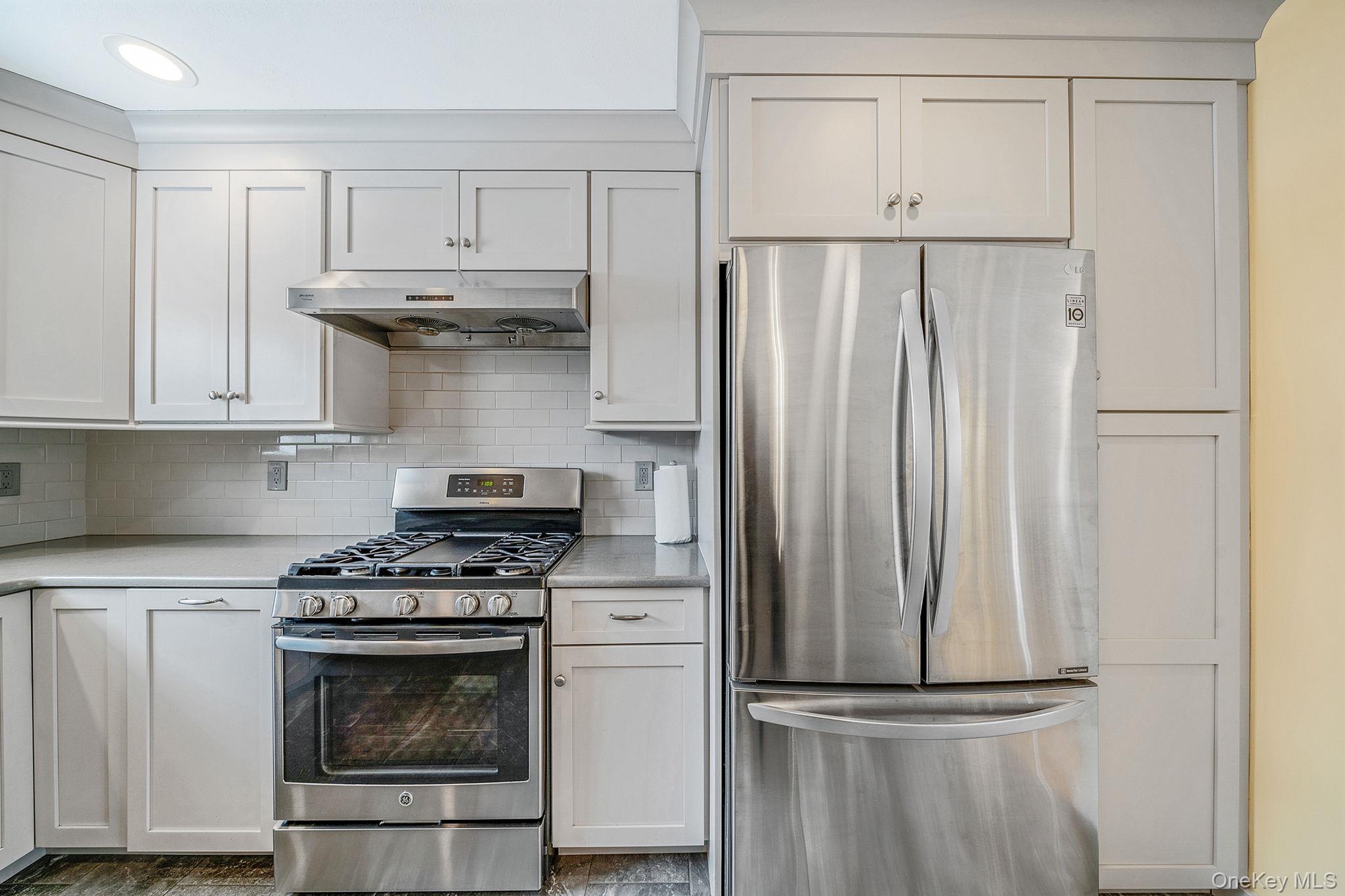 1663 Claas Avenue Holbrook, NY 11741 - Photo 7 of 28 a kitchen with white cabinets and stainless steel appliances