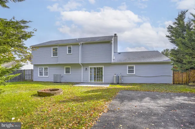 a view of a brick house with a big yard and large trees
