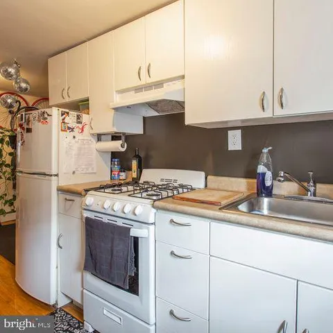 a kitchen with granite countertop a sink stainless steel appliances and cabinets