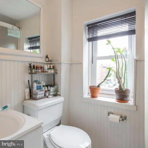 a bathroom with a toilet a sink and a window