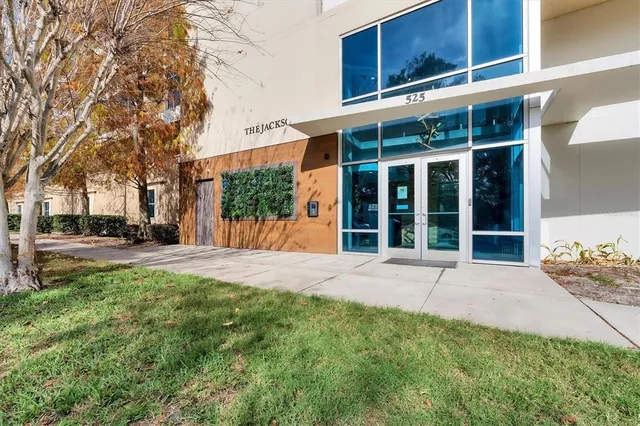a view of a house with a yard and large tree