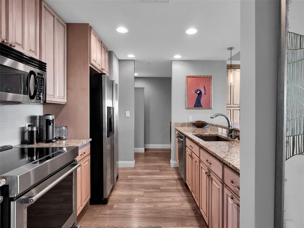 525 East Jackson Street Orlando, FL 32801 - Photo 39 of 65 a kitchen with stainless steel appliances granite countertop a stove and a refrigerator
