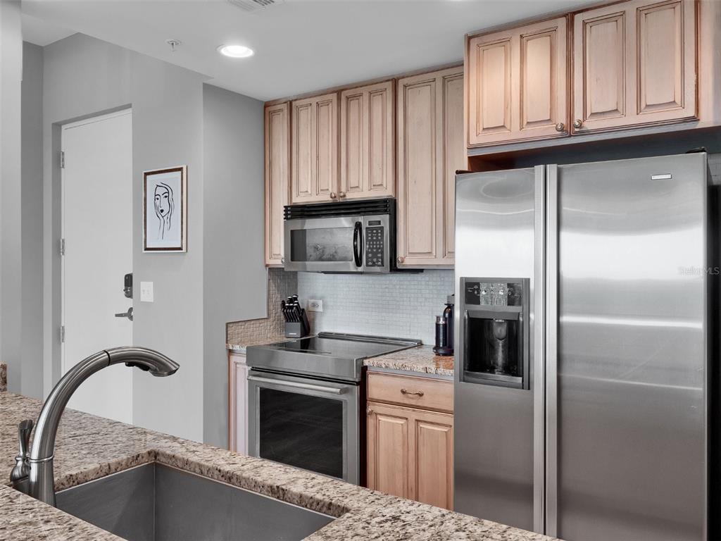 525 East Jackson Street Orlando, FL 32801 - Photo 42 of 65 a kitchen with stainless steel appliances granite countertop a refrigerator a stove a sink and a microwave