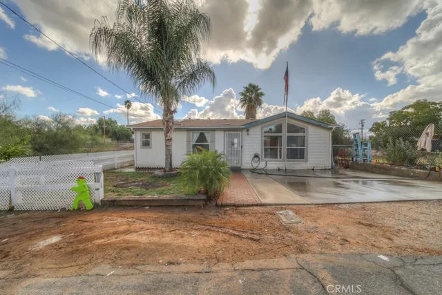 a front view of a house with a yard and potted plants