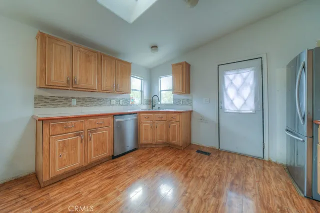 a kitchen with white cabinets and wooden floor