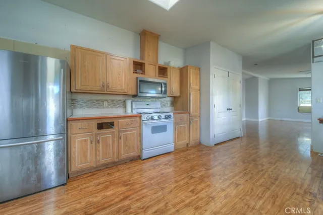 a kitchen with stainless steel appliances granite countertop a refrigerator and a stove top oven