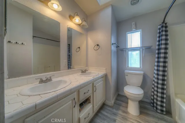 a spacious bathroom with a granite countertop sink toilet a large mirror and shower
