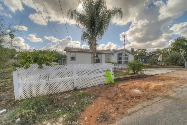 a view of a house with a small yard and large tree