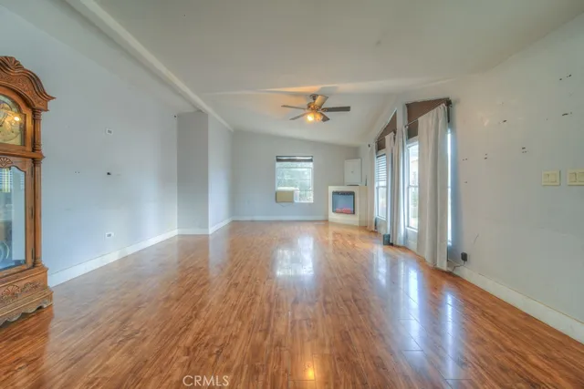 a view of an empty room with window and wooden floor