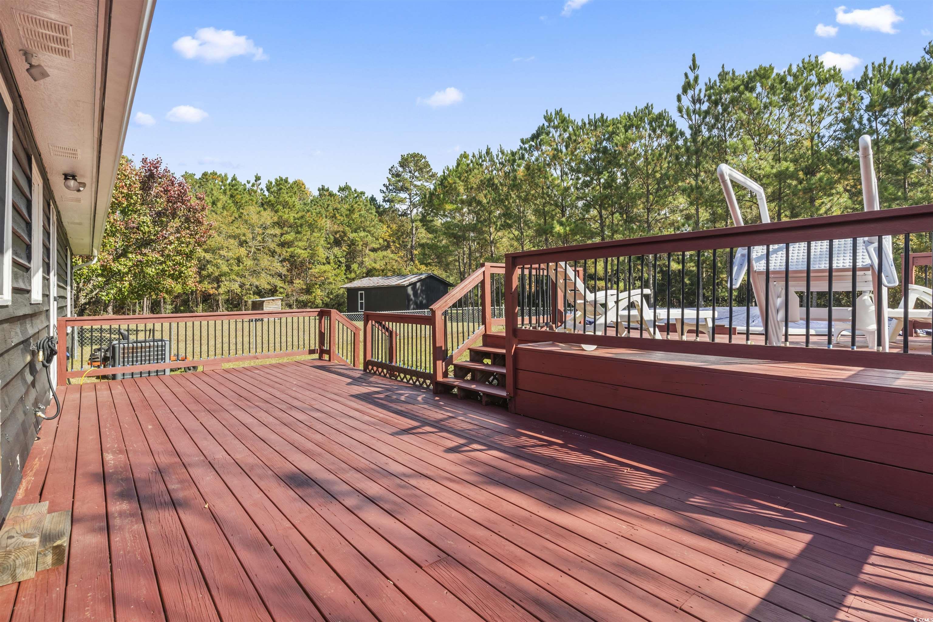 1495 Wilderness Lane Loris, SC 29569 - Photo 15 of 37 Wooden deck with view of wooded area and an outbuilding