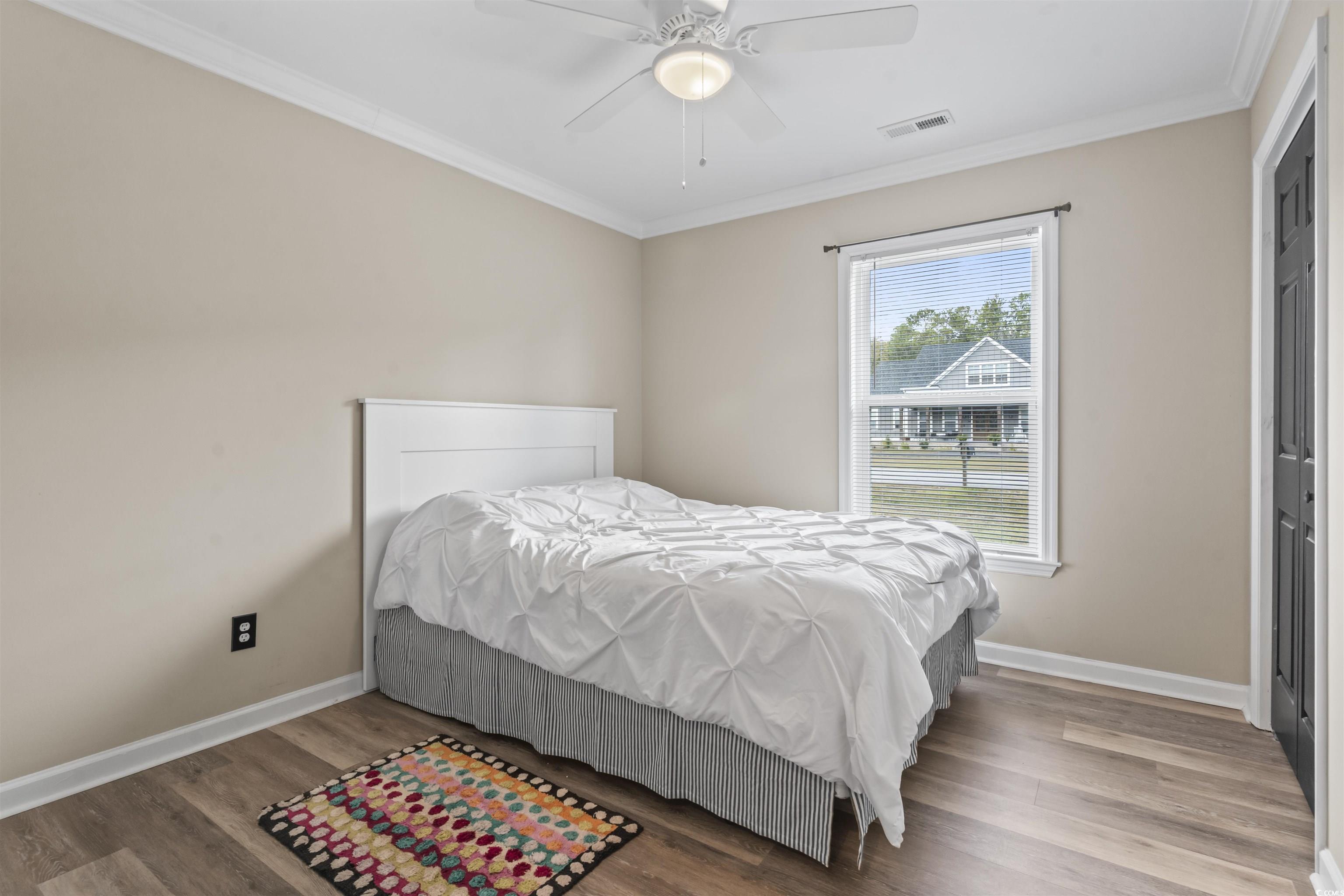 1495 Wilderness Lane Loris, SC 29569 - Photo 18 of 37 Bedroom with crown molding, wood finished floors, a ceiling fan, and a closet