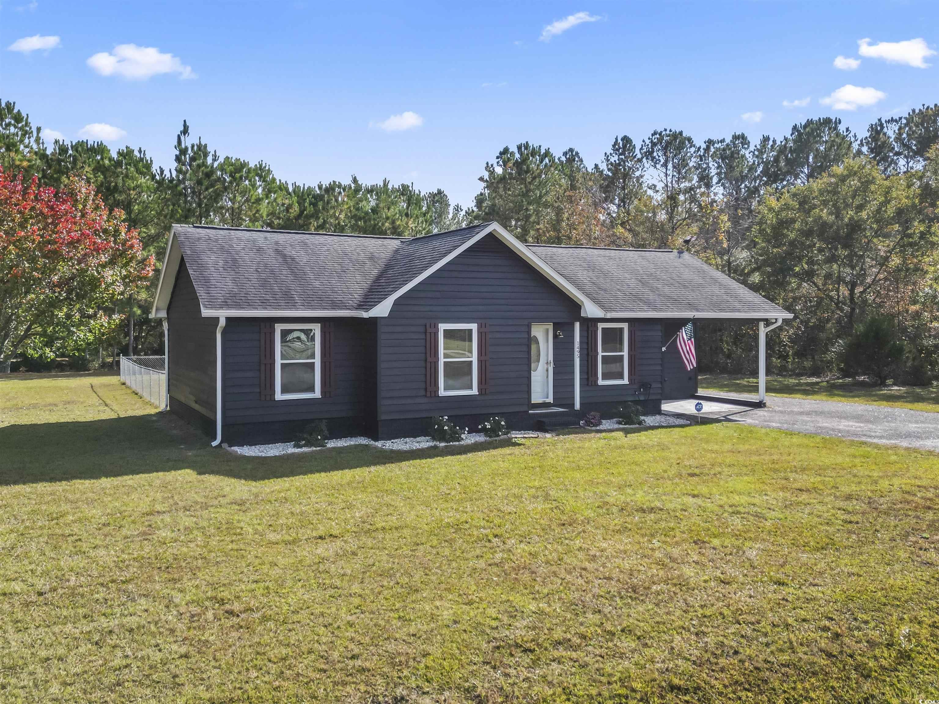1495 Wilderness Lane Loris, SC 29569 - Photo 2 of 37 Ranch-style home with a front lawn, roof with shingles, and view of scattered trees