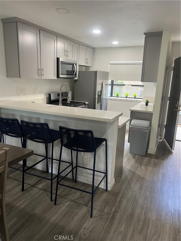 4140 Workman Mill Road, Unit 277 Whittier, CA 90601 - Photo 8 of 10 a kitchen with stainless steel appliances a table chairs refrigerator microwave and cabinets