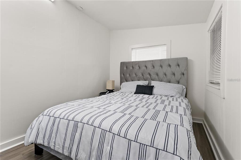 904 Lakeview Road, Unit A Clearwater, FL 33756 - Photo 13 of 25 a bedroom with a bed and a night stand