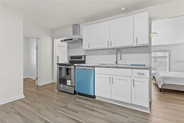 a kitchen with granite countertop white cabinets and white appliances