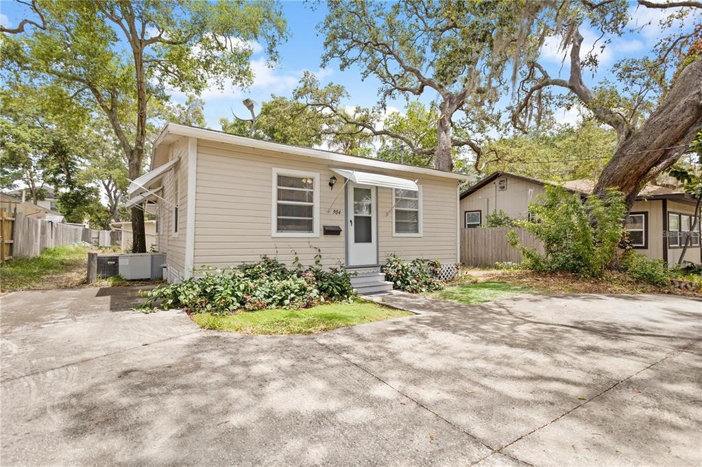 904 Lakeview Road, Unit A Clearwater, FL 33756 - Photo 2 of 25 a front view of a house with a yard and a glass top table