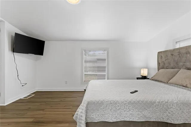 a bedroom with a bed and a flat screen tv