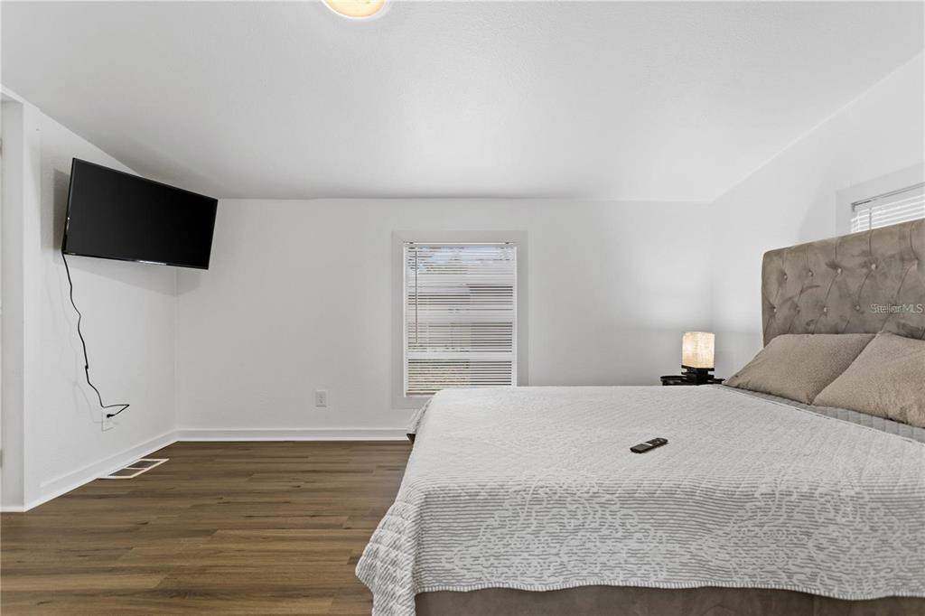 904 Lakeview Road, Unit A Clearwater, FL 33756 - Photo 8 of 25 a bedroom with a bed and a flat screen tv