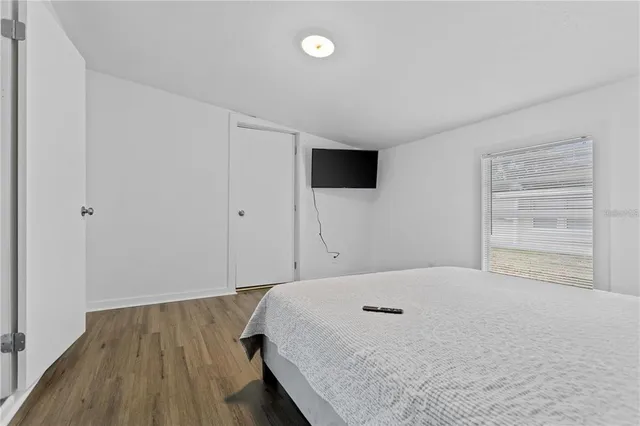 a bedroom with a bed and a flat screen tv