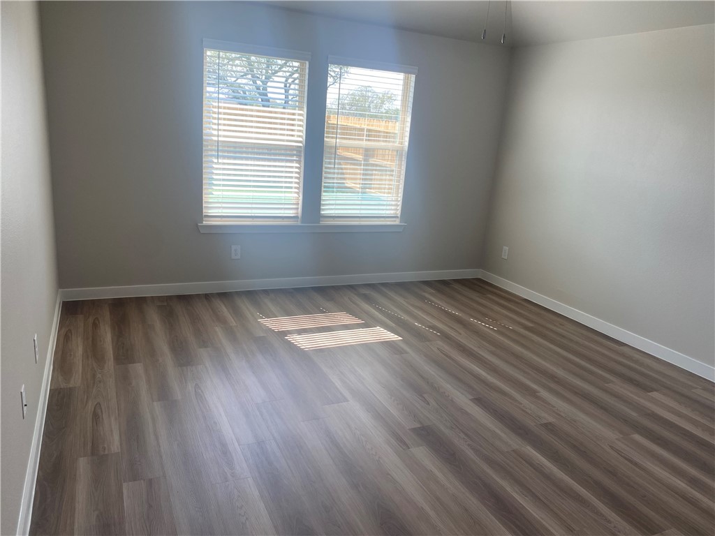 1504 Choctaw Road Sinton, TX 78387 - Photo 3 of 12 an empty room with wooden floor and windows