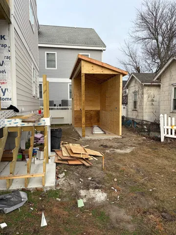 a backyard of a house with barbeque oven table and chairs
