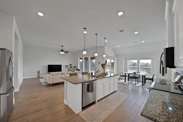 a large kitchen with stainless steel appliances kitchen island granite countertop a large island a stove a sink a dining table and chairs