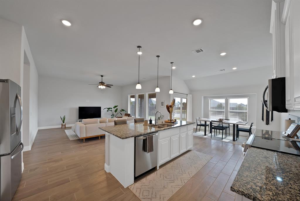 4054 Grove Valley Road Midlothian, TX 76065 - Photo 11 of 25 a large kitchen with stainless steel appliances kitchen island granite countertop a large island a stove a sink a dining table and chairs